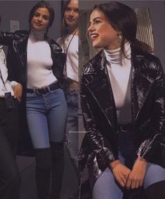 four women in black and white outfits posing for the camera