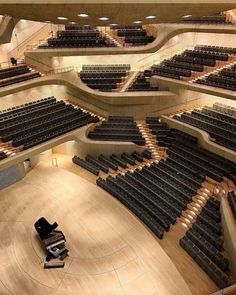 an empty auditorium with rows of seats and a car on the floor in front of it