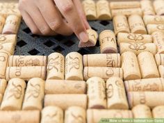 a person touching the corks on top of a table