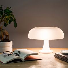 a lamp that is on top of a table next to a book and remote control