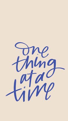 the words one thing at a time written in blue ink on a light beige background