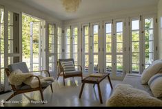 a living room filled with furniture and lots of windows