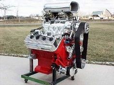 a red engine on a cart in front of some grass