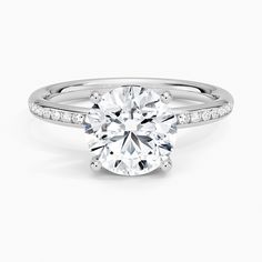 a round brilliant cut diamond ring with pave set shoulders