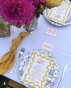 the table is set with place settings and flowers