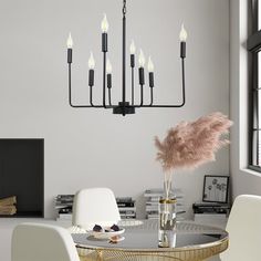 a dining room table with chairs and a chandelier hanging from the ceiling above it