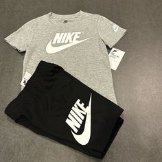 Nike Boy's T-Shirt & Shorts Futura Logo 2-Piece Set. Color:Black/Grey. New With Tags. Fabric Type: 60% Cotton 40%Polyester Nike Sets With Graphic Print And Crew Neck, Nike Crew Neck Sets With Graphic Print, Nike Graphic Print Crew Neck Sets, Nike Sets With Letter Print And Short Sleeve, Gray Sporty Tops For Playwear, Gray Playwear Sets For Summer, Nike Black Summer Sets, Black Short Sleeve Sportswear Set, Nike Cotton Sportswear Sets