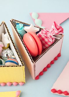 an open box filled with assorted items on top of a blue table next to pink and yellow flags