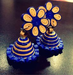 two blue and yellow vases sitting on top of a black table next to each other