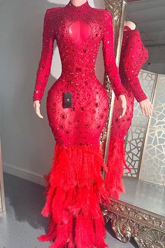 a mannequin wearing a red dress with feathers on it and a mirror in the background