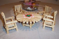 a wooden table and chairs made out of sticks with fruit bowl in the middle on top