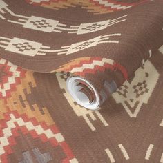 a brown and white area rug with an intricate design on the bottom, along with a roll of tape