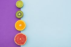 various fruits are arranged in a row on a purple and blue background