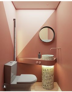 a bathroom with a toilet, sink and mirror on the wall next to a trash can