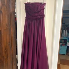 a purple dress hanging up on a door