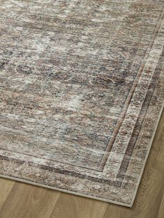 an area rug with wood flooring and a beige, blue, red and green color scheme