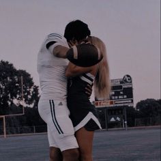 two people embracing each other on a field