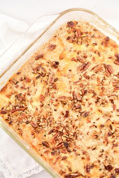 a casserole dish with pecans in it on a white cloth and napkin