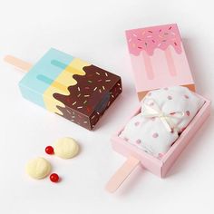 an ice cream sundae box with two popsicles and a candy bar wrapper