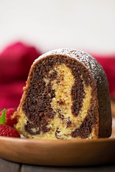 a piece of chocolate marble cake on a plate with raspberries next to it