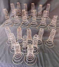 a bunch of metal springs sitting on top of a black cloth covered table next to each other