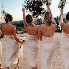 the bridesmaids are walking down the road with their bouquets in each hand