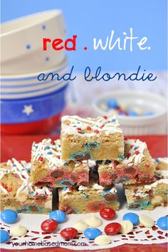 red, white and blue blondie bars stacked on top of each other in front of plates