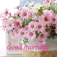 a basket filled with pink flowers sitting on top of a table