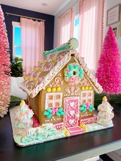 a gingerbread house decorated with icing and sprinkles on a table