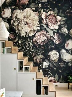 a room with flowers on the wall and stairs