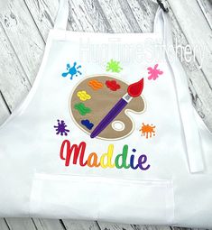 an apron with the word's name painted on it and a paintbrush next to it