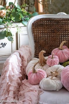 some pink and white pumpkins on a chair