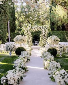 an outdoor ceremony with white flowers and greenery