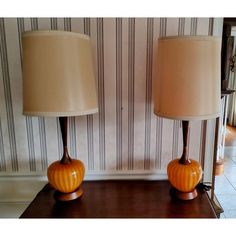 two lamps sitting on top of a wooden table