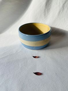 a blue and yellow bowl sitting on top of a white cloth