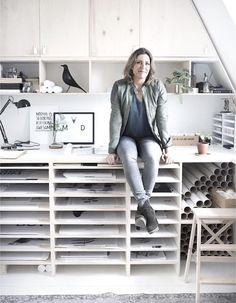 a woman sitting on top of a white desk