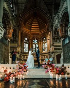 the bride and groom are standing at the alter