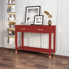 a red console table with two pictures on it