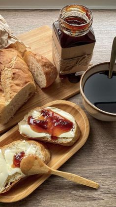 bread with jam and butter on wooden trays next to cup of coffee, spoon