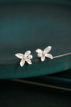 Embrace the beauty of simplicity with our White Lilac Flower Enamel Earring Studs, delicately decorated with a freshwater pearl and a sparkling zircon. These tiny yet elegant earrings capture the essence of purity and innocence, symbolized by the white lilac flower. Pearl Earring Studs, White Lilac, Flower Earring, Bridal Earrings Pearl, Lilac Flowers, Earring Studs, Delicate Design, Enamel Flower, Enamel Earrings