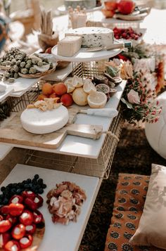 a table filled with plates and bowls of food on top of each other next to pillows