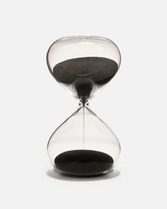 an hourglass sitting on top of a white surface