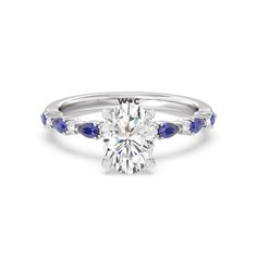 a diamond and blue sapphire engagement ring with two stones on the side, set in white gold