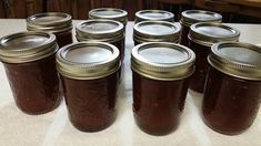 many jars are lined up on the table and ready to be filled with jams