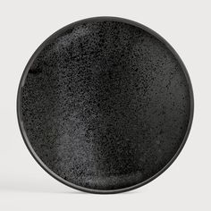 a black plate sitting on top of a white table