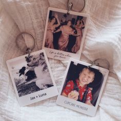 three keychains with pictures of people on them sitting on a white cloth covered bed