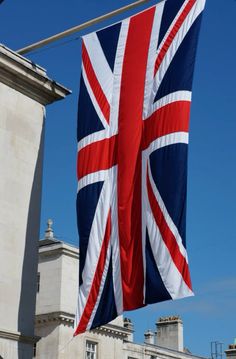 the british flag is flying in front of an old building