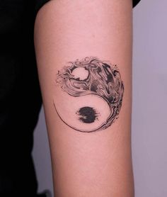 a woman's arm with a tattoo on it that looks like a yin - yang symbol