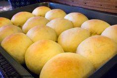 a pan filled with lots of yellow bread rolls