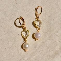 These earrings are composed of vintage channel set clear heart charm with attached pearl drops.  The hoops are 14mm in size, have a lever back closure, and are made of 14k gold plated brass. Vintage Channel, Clear Heart, Channel Set, Vintage Crystal, Crystal Heart, Pearl Drop Earrings, Pearl Drop, Charm Earrings, Barrettes